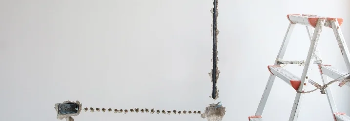 Stromkabel werden an einer Wand verlegt